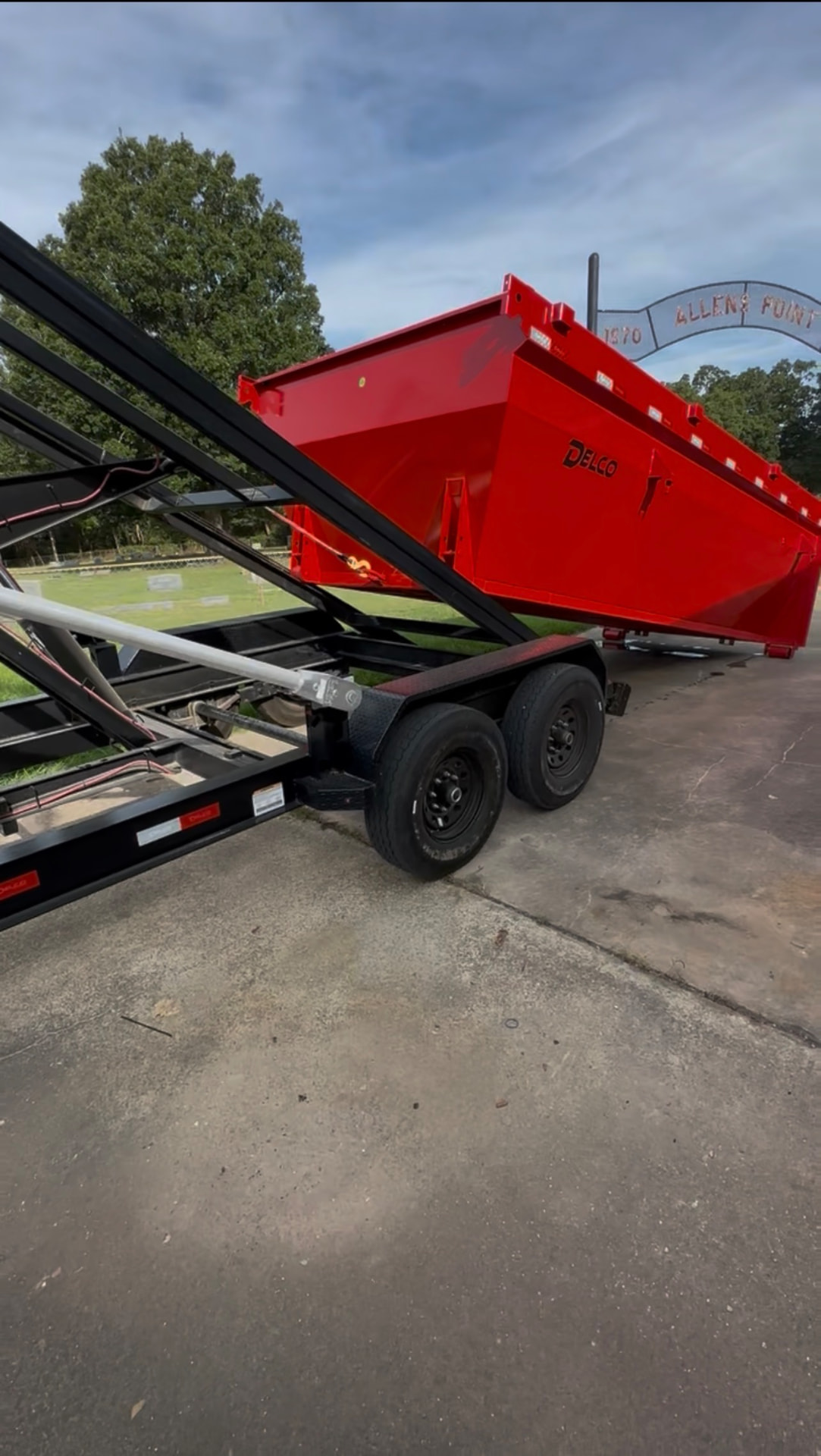 Red 16-yard roll-off dumpster set on a driveway in Honey Grove, TX by HomeHaven Dumpsters